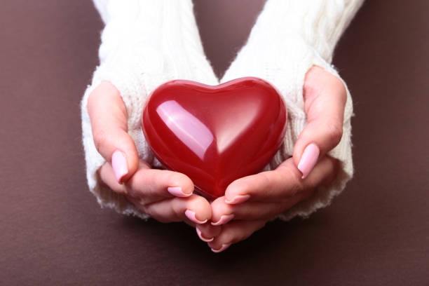 istock Female hands giving red heart, isolated on gold background 865464536