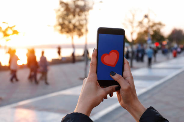 istock Hand holding smart phone with sending heart 865466908