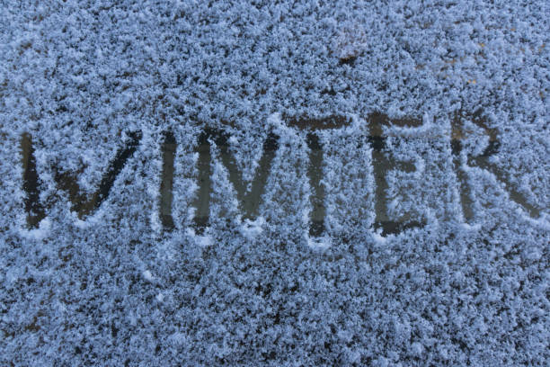 istock Winter inscription - drawing on snow in winter, pattern on winter glass 865473722
