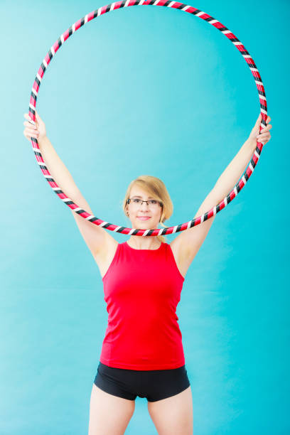 istock Fit woman with hula hoop doing exercise 865473852