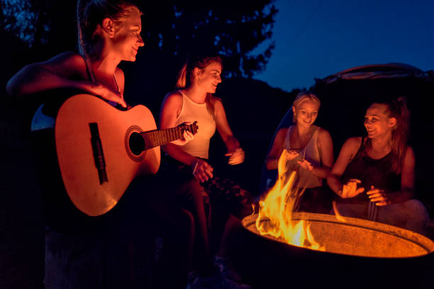 istock Friends enjoying music near campfire 865481330