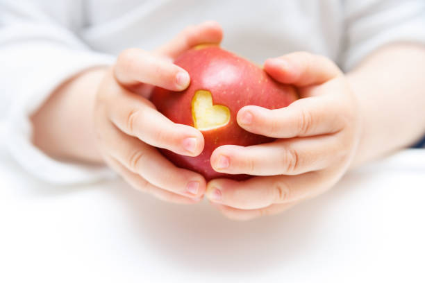 Baby hands with apple isolated on white stock photo