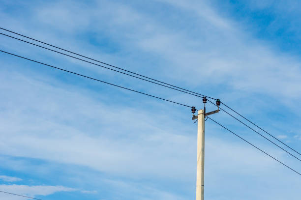 istock electric pole with wires against blue sky 865482014