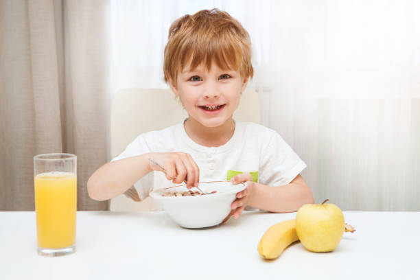 istock Little boy eating breakfast on table in the kitchen 865487502