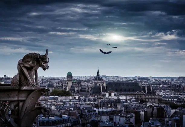 Chimera (gargoyle) of the Cathedral of Notre Dame de Paris overlooking Paris on Halloween, France