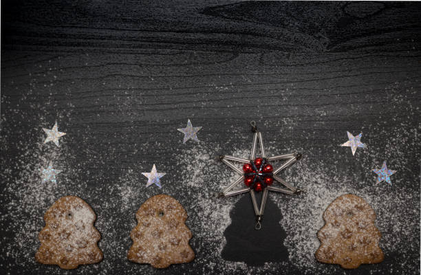 Cookies in shape of christmas tree with stars on dark wooden background stock photo