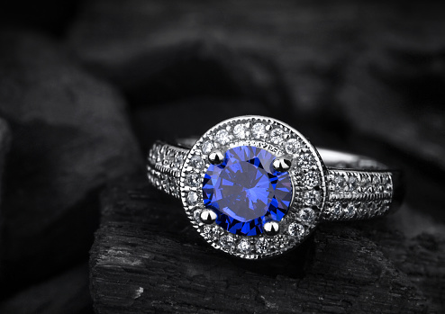 joyas anillo witht sapphir azul grande sobre fondo negro carbón photo