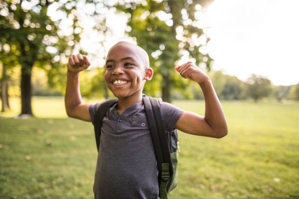 bambino che mostra il muscolo - african descent confidence african culture education foto e immagini stock