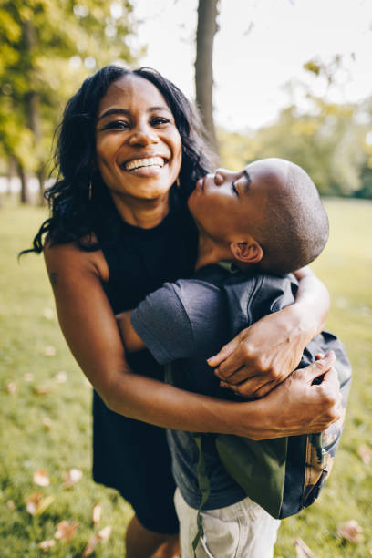 madre e hijo abrazándose en el parque - family single mother black mother fotografías e imágenes de stock