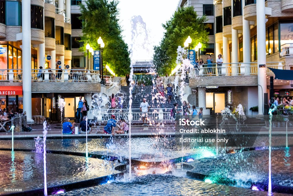 Closeup View Of Colorful Fountain At Night In Georgetown Waterfront Park Harbor With Restaurants And People Walking At Waterfront Park Stock Photo - Download Image Now - iStock