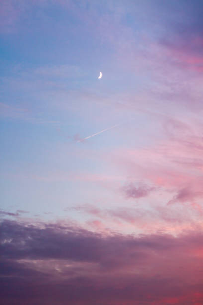 istock Sunset Crescent Moon Blue Sky Red and Purple Clouds 865524436