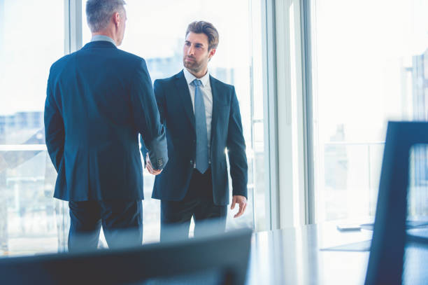 istock Mature and young businessmen shaking hands. 865526700