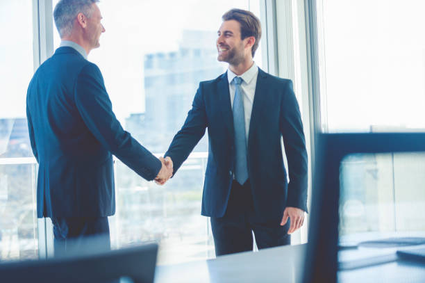 istock Mature and young businessmen shaking hands. 865526754