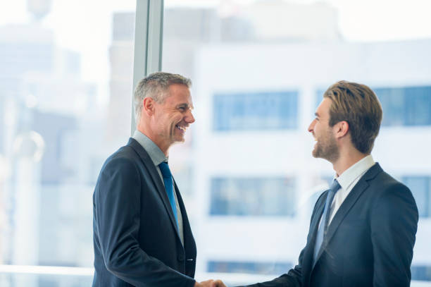 istock Mature and young businessmen shaking hands. 865527856