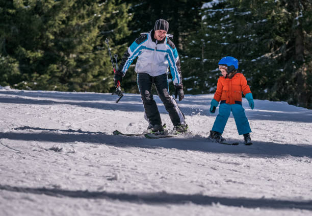 istock adorable young boy is learning to ski from his father 865534236