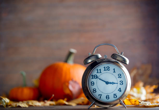 istock Vintage alarm clock and maple tree leaves with pumpkins 865541680