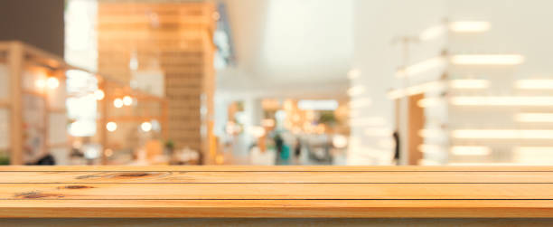 istock Wooden board empty table top blurred background. Perspective brown wood table over blur in coffee shop background. Panoramic banner - can be used mock up for montage products display or design. 865547648