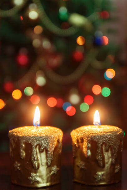 istock Christmas candle in front of a Christmas tree with sparkling lights and copy space. 865548856