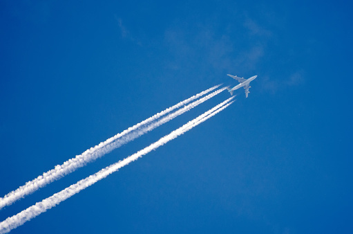 Airplane in the sky with a trace of steam contrail