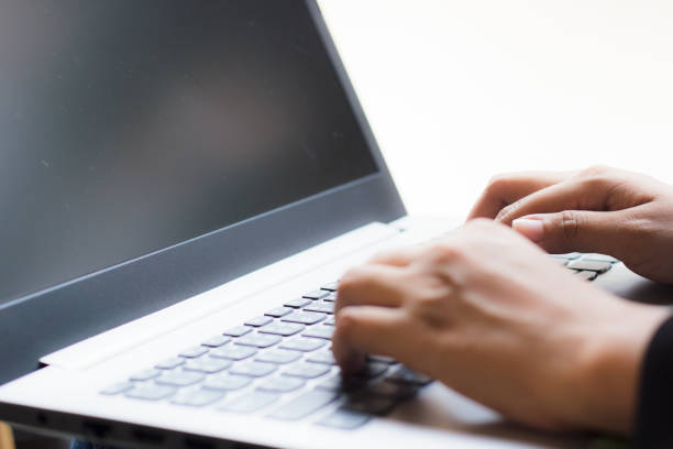 istock Business hand using laptop for working. Hand use laptop checking e-mail or message. Close up hand of business using laptop on white background. Hand of businessman for fill information in the laptop. 865549160
