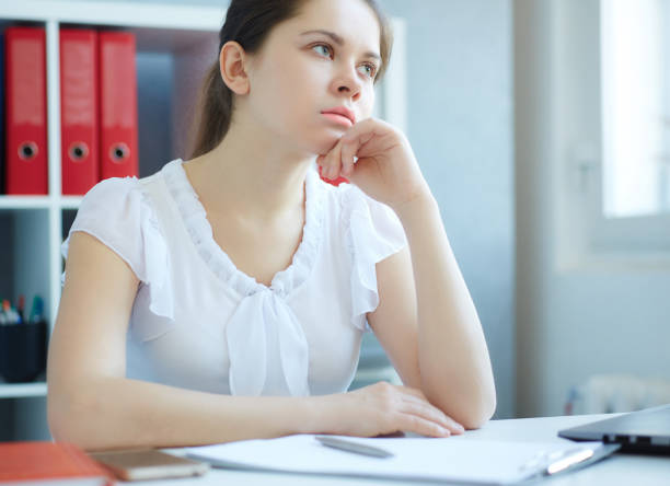 istock Bored female office worker sits at her desk and look at computer screen. 865549792