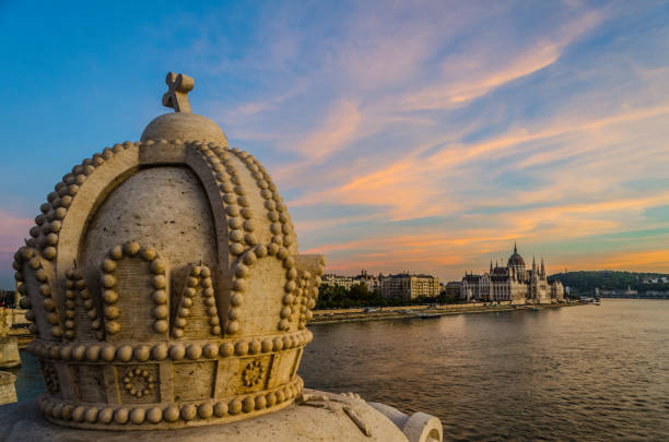 The Crown of Saint Stephen (The Holy Crown of Hungary) on Margaret bridge in Budapest, Hungary with the Danube and the iconic Hungarian Parliment building in the background.
