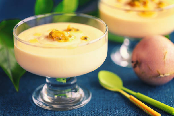 Passion fruit mousse in glass ramekin on dark blue background stock photo