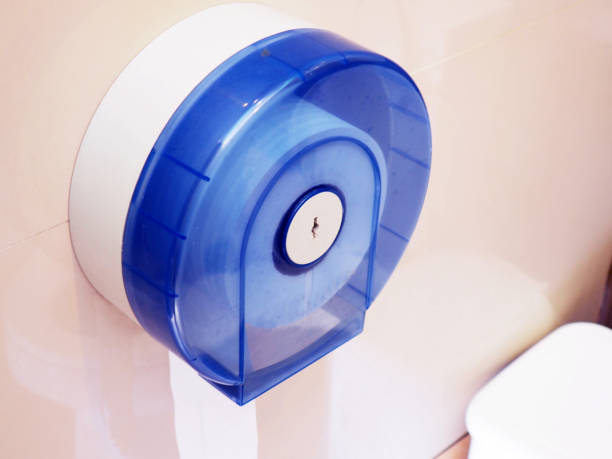 istock Wall-mounted blue tissue paper dispenser in cubicle toilet 865556332