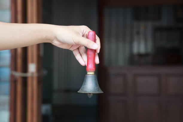 Close up of a metal bell hanging from the wall