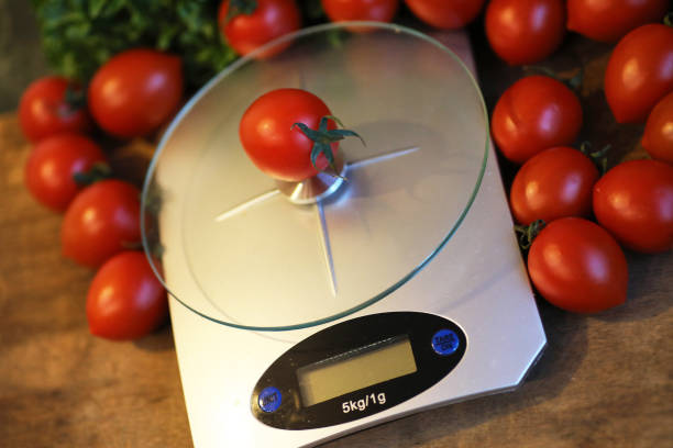 istock Fresh tomatoes on kitchen scales weighing 865570126