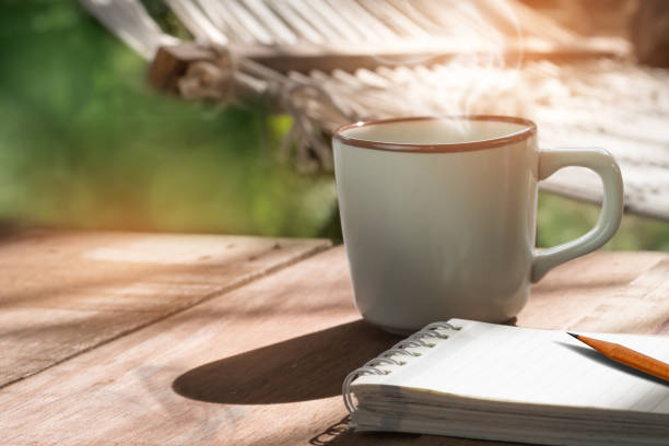 istock Free time coffee mug next to notepad and blurred hammock background 865570838