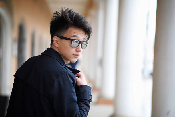 istock Asian young man in a coat on the street 865573196
