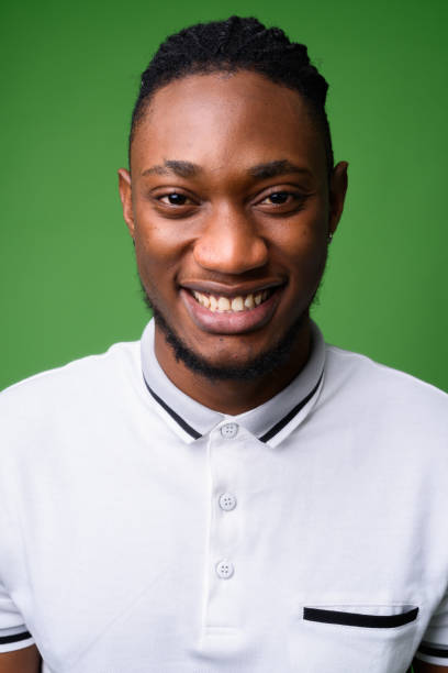 joven guapo hombre de kenia sobre fondo verde - polo shirt african ethnicity men african descent fotografías e imágenes de stock