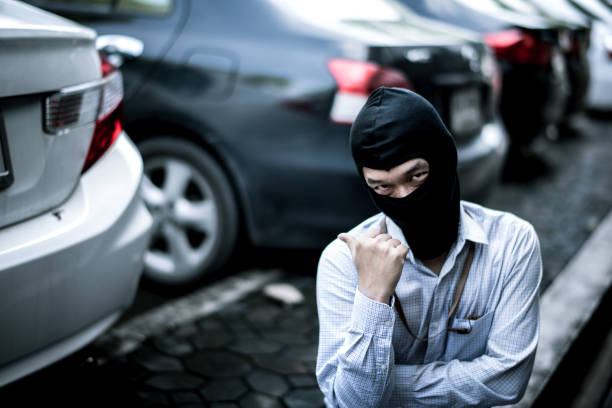 istock robber in black mask with car. robbery and crime concept. 865585916