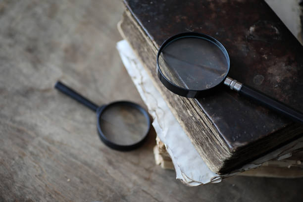 istock Old books on a wooden table and magnifier 865589978