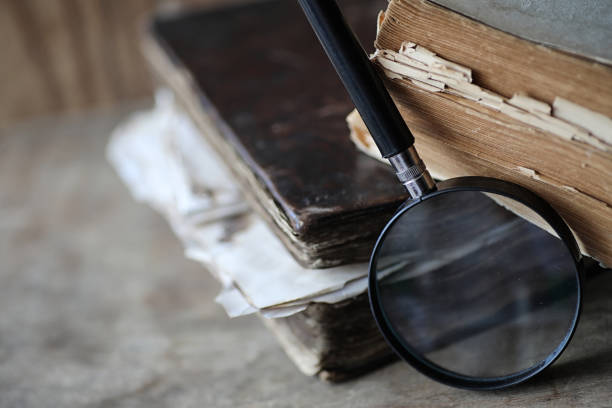 istock Old books on a wooden table and magnifier 865590252