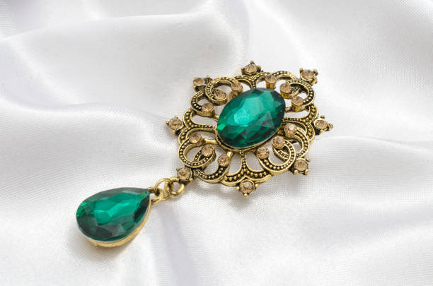 istock golden vintage brooch with emeralds on silk 865590258