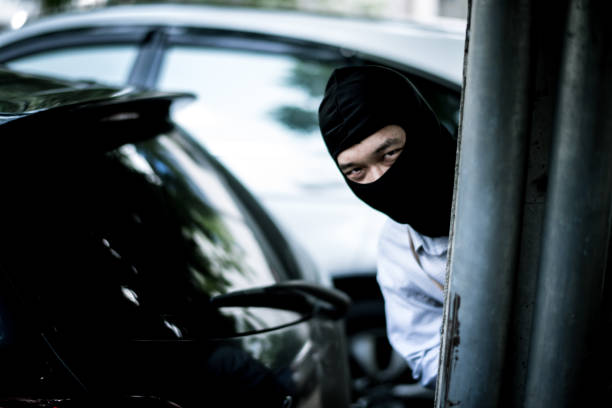 istock robber in black mask with car. robbery and crime concept. 865593298