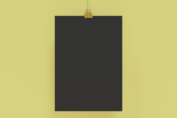 istock Blank black poster with binder clip mockup on yellow background 865601248