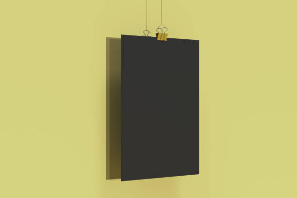 istock Blank black poster with binder clip mockup on yellow background 865601314