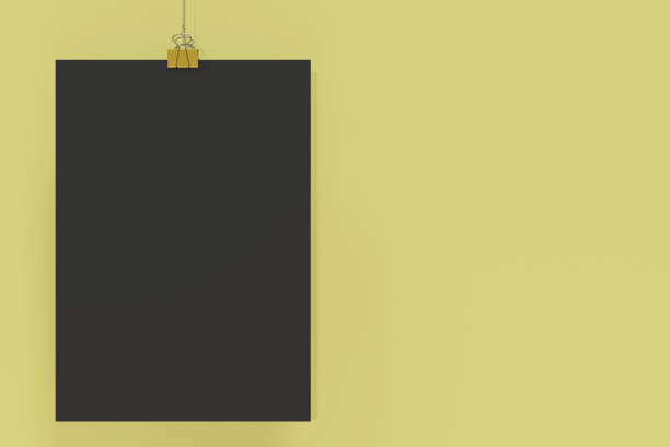 istock Blank black poster with binder clip mockup on yellow background 865601328
