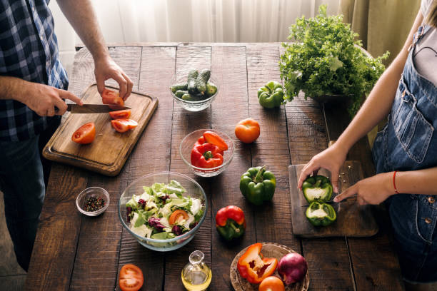 istock Married couple cooking together dinner vegetables salad in home kitchen, top view 865604340