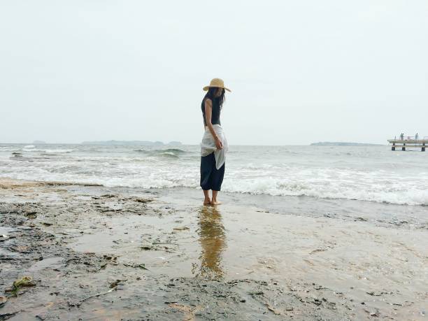 istock Woman Standing on Muddy Beach 865611594
