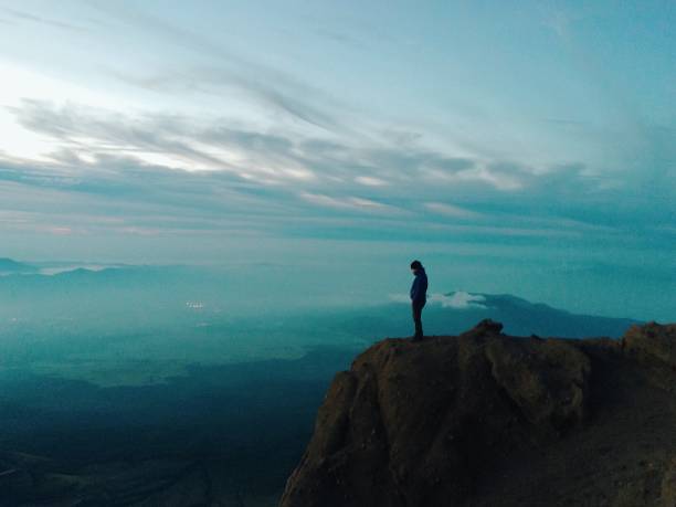 istock Side View Full Length Of Man Standing On Mountain Against Sky During Sunrise 865612280