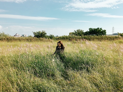 Woman Taking Stroll in Long Grass Field