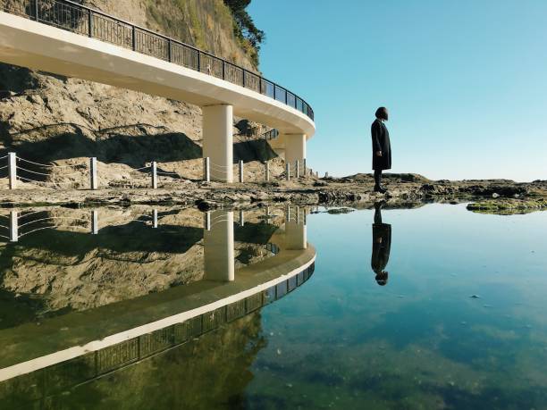 mulher em pé por mar e reflexão - self reflection - fotografias e filmes do acervo