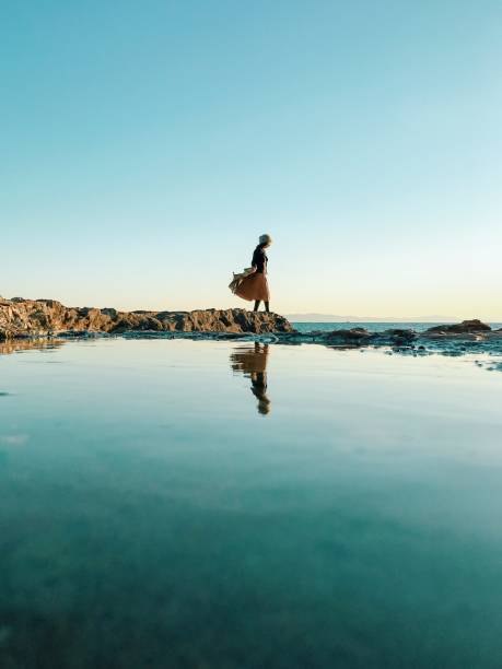 donna in piedi sulla roccia accanto al mare - mind trip foto e immagini stock