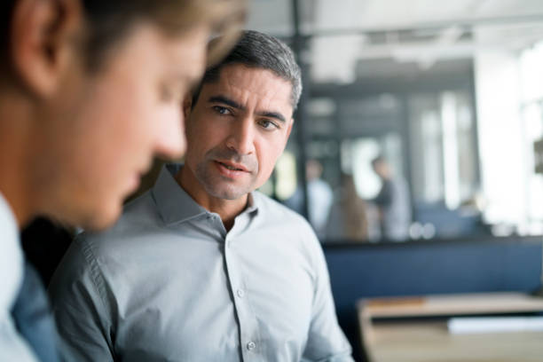 istock Mature businessman looking at colleague in office 865615608