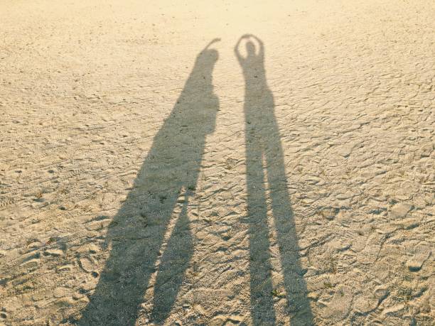 istock Shadow of friends on beach sand 865615614