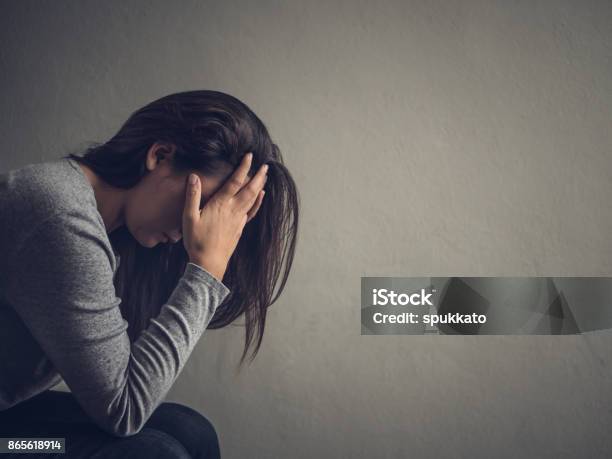 Photo libre de droit de Femme Déprimée Assise Sur Une Chaise Dans Une Pièce Sombre À La Maison Leroy Triste Notion Démotion banque d'images et plus d'images libres de droit de Femmes